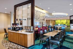 um restaurante com mesas e cadeiras e um bar em SpringHill Suites by Marriott Murray em Murray