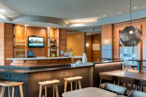 un restaurante con un bar con mesas y sillas en SpringHill Suites Detroit Auburn Hills, en Auburn Hills