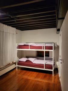 two bunk beds in a room with a wooden floor at Viktoria HOSTEL in Antwerp