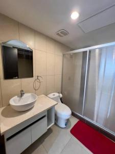 a bathroom with a sink and a shower and a toilet at Depa en piso alto! Vista al rio y parqueo in Guayaquil