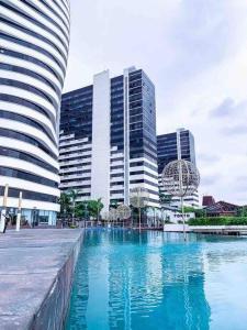 a pool of blue water in front of tall buildings at Depa en piso alto! Vista al rio y parqueo in Guayaquil