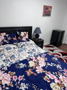 a bed with a blue comforter with flowers on it at DARON HOMES in Brampton