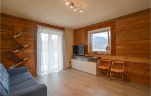 sala de estar con paredes de madera y sofá azul en 4 Bedroom Lovely Home In Chiusa Di Pesio, en Chiusa di Pesio