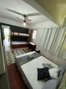 1 dormitorio con 1 cama y ventilador de techo en Casa de Praia LOFT 1 en Saquarema