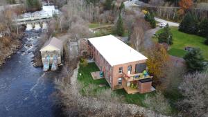 an aerial view of a house next to a river at Burk's Fall Modern Mill House Apt 3 in Burks Falls