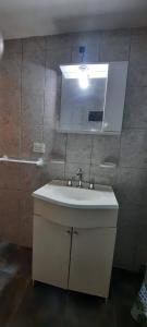 y baño con lavabo y espejo. en cabañas Los Pinares en Miramar