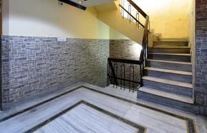 a staircase in a room with a brick wall at OYO Hotel Jammu Palace in Jammu