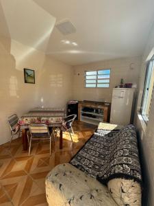 ein Wohnzimmer mit einem Sofa, einem Tisch und einem Kühlschrank in der Unterkunft Condominio Horizontal União in Florianópolis