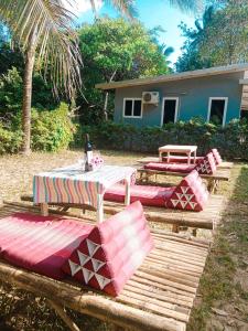 a group of picnic tables and benches in front of a house at family resort in Ko Phayam