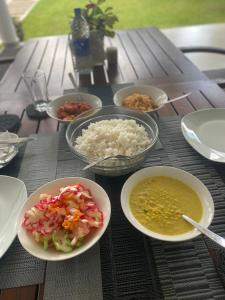 a table with bowls of food and rice on it at Villa Riverside in Aluthgama