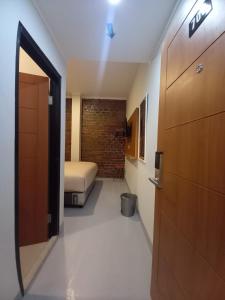 Habitación pequeña con cama y puerta en Pondok Indah24 Hotel en Yakarta
