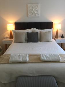 a bedroom with a large bed with two pillows on it at Killcare Beach House in Killcare