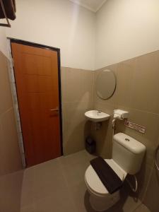 y baño con aseo y lavamanos. en Pondok Indah24 Hotel en Yakarta