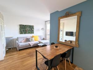 a living room with a table and a mirror at Cosy little nest next to Paris in Issy-les-Moulineaux