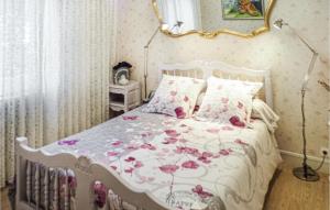 Un dormitorio con una cama blanca con flores rosas. en 2 Bedroom Awesome Home In Pierre-chtel en Pierre-Châtel