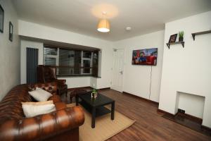 拉夫堡的住宿－Contractors - Relocators - Family，客厅配有真皮沙发和桌子