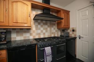a kitchen with a black stove top oven at Contractors - Relocators - Family in Loughborough