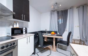 a kitchen with a table with chairs and a microwave at Pet Friendly Apartment In Krsan in Kršan