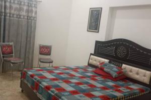 1 dormitorio con 1 cama y 2 sillas en Salasar Sadan, en Bikaner