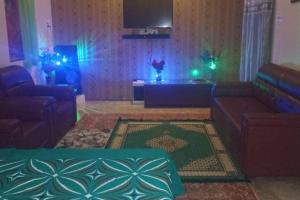 a living room with two couches and green lights at Salasar Sadan in Bikaner