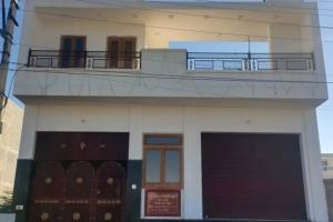 a building with a balcony and a garage at Salasar Sadan in Bikaner