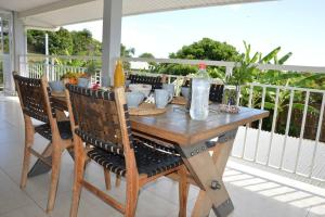 a wooden table with chairs on a porch at Fare fenua Maison 270m2 12p in Papeete