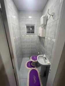 La petite salle de bains est pourvue d'un lavabo et de toilettes. dans l'établissement Casa com ótima localização, à Foz do Iguaçu