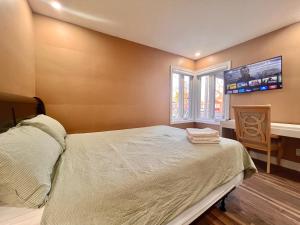 1 dormitorio con 1 cama y TV en la pared en Newly Renovated Home in Toronto Near Subway, en Toronto