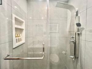 a bathroom with a shower with a glass door at Newly Renovated Home in Toronto Near Subway in Toronto