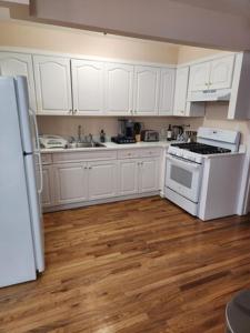 a kitchen with white cabinets and a white stove at Hotel Blu NY LLC in Brooklyn