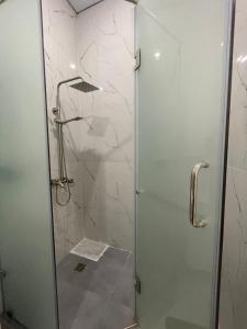 y baño con ducha y puerta de cristal. en Жилой комплекс Махаббат, en Aktau