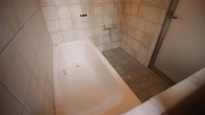 a white bath tub in a bathroom with a shower at Maison d'hôtes KIRISIMIZU - Vacation STAY 40997v in Nagano
