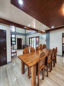 uma grande sala de jantar com uma mesa de madeira e cadeiras em Triple J Villa Puerto Galera em Puerto Galera
