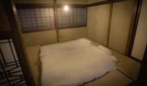 ein kleines Zimmer mit einem weißen Bett. in der Unterkunft Maison d'hôtes KIRISIMIZU - Vacation STAY 40997v in Nagano
