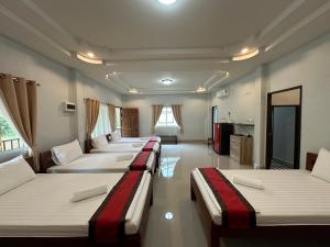 a row of beds in a room with a kitchen at Brown Andaman Krabi in Krabi town