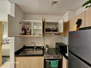 une petite cuisine avec un évier et un réfrigérateur dans l'établissement Ensuite one bedroom in a 2-bedroom with a shared living room, à Dubaï 2 autres photos