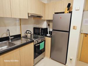 une cuisine avec un réfrigérateur en acier inoxydable et un évier dans l'établissement Ensuite one bedroom in a 2-bedroom with a shared living room, à Dubaï