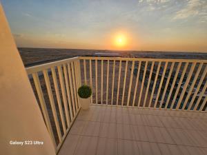 - un balcon avec vue sur l'océan au coucher du soleil dans l'établissement Ensuite one bedroom in a 2-bedroom with a shared living room, à Dubaï