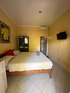 a bedroom with two beds and a flat screen tv at Sari Buana Bed & Breakfast in Kuta