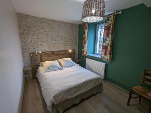 1 dormitorio con cama y pared verde en Gîte Traînou, 4 pièces, 6 personnes - FR-1-590-419, en Traînou
