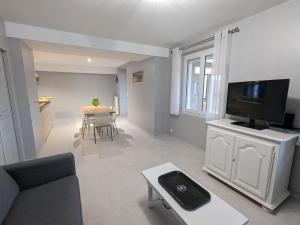 een woonkamer met een bank, een tv en een tafel bij Gîte Traînou, 4 pièces, 6 personnes - FR-1-590-419 in Traînou
