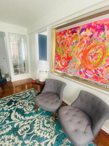 een kamer met 2 stoelen en een schilderij aan de muur bij Lechón Marina in Viña del Mar