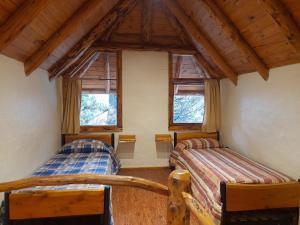 sypialnia z 2 łóżkami i 2 oknami w obiekcie Cabaña El Viaje w mieście Bariloche