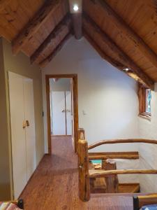 Habitación con cama y pasillo con puerta en Cabaña El Viaje en San Carlos de Bariloche