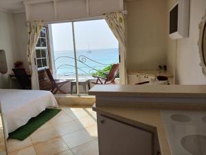 - une cuisine avec un lit et une vue sur l'océan dans l'établissement Coral Lane Beach Apartments, à Saint James