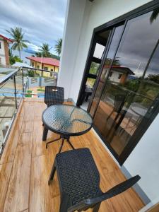 uma varanda com 2 cadeiras e uma mesa e cadeiras em Triple J Villa Puerto Galera em Puerto Galera