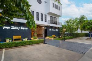 un edificio blanco con un cartel que lee fama de cocina de carrera en The Modeva Hotel en Kanchanaburi