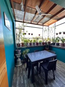 a table and chairs in a room with potted plants at JMCL RESIDENCES in Tacloban