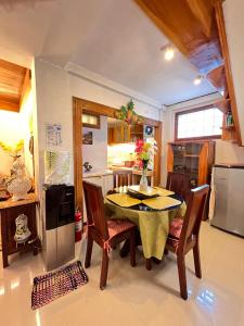 a kitchen with a table and chairs and a refrigerator at JMCL RESIDENCES in Tacloban