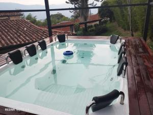 a hot tub on a deck with chairs at FINCA APOLOo in Medellín